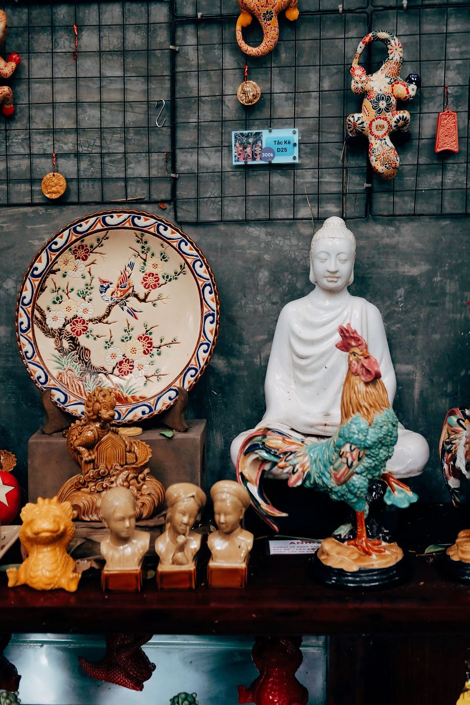 Glazed ceramic figurines including a white seated figure, a painted rooster and small busts